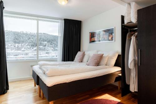 a bed in a room with a large window at Scandic Hell in Hell