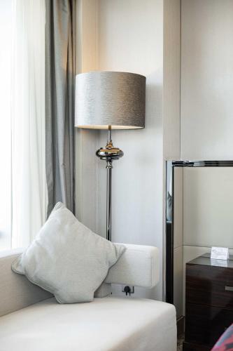 a room with a lamp and a couch and a chair at Shenzhen LANGYUE International Hotel in Longgang