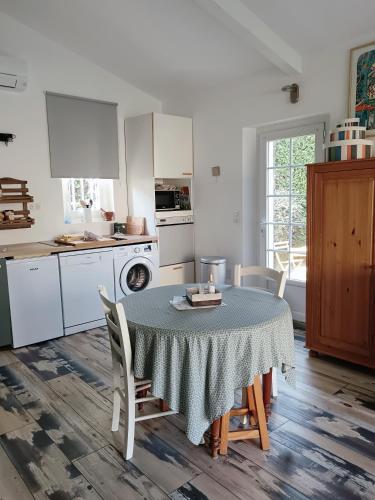une cuisine avec une table et des chaises dans une cuisine dans l'établissement Gîte Odonate, à LʼIsle-sur-la-Sorgue
