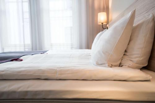 a bed with white sheets and pillows in a bedroom at Scandic No 53 in Stockholm
