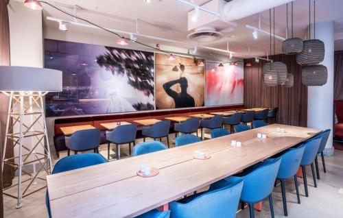a conference room with a long table and blue chairs at Scandic No 53 in Stockholm