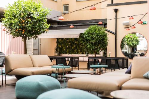 a patio with couches and tables and plants at Scandic No 53 in Stockholm