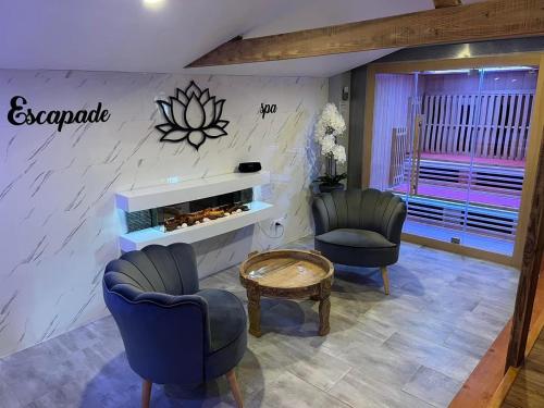 a living room with two chairs and a table at Escapade et spa Insolite in Saint-Gilles-de-Crétot