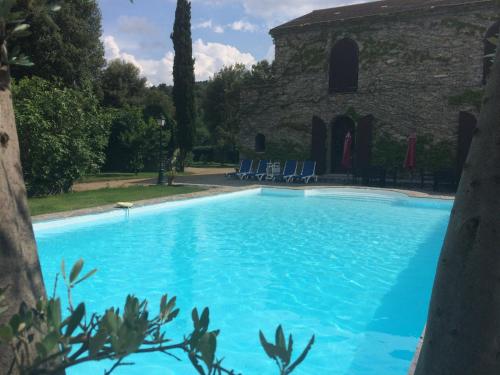 a large blue swimming pool in front of a building at U Palazzu Corte in Corte