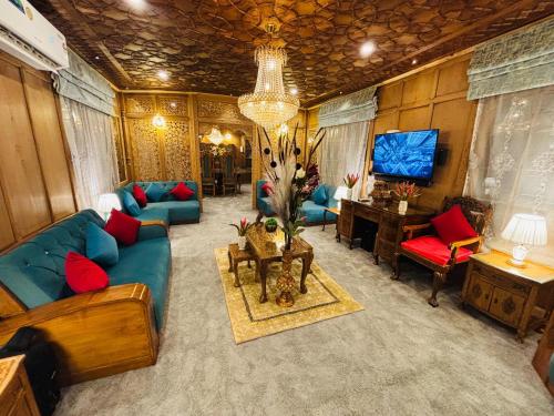 a living room with blue couches and a tv at Shabistan Premium Houseboats in Srinagar