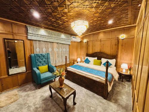 a bedroom with a bed and a blue chair at Shabistan Premium Houseboats in Srinagar