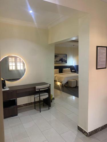 a bedroom with a bed and a desk in a room at Centurion Aparthotel in Abuja