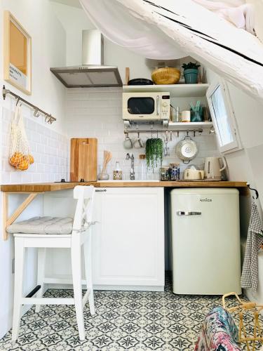 une cuisine avec un comptoir blanc et une table dans l'établissement Studio dans le centre historique avec WIFI et TV, à Montpellier