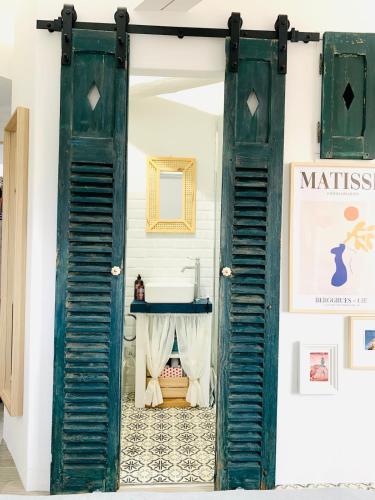 - une vieille porte avec volets dans une chambre avec lavabo dans l'établissement Studio dans le centre historique avec WIFI et TV, à Montpellier
