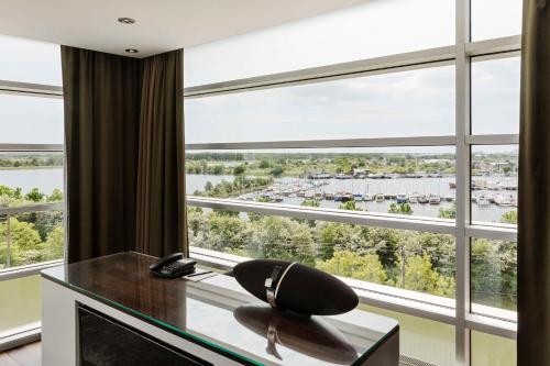 a room with a desk with a chair in front of a large window at Scandic Sluseholmen in Copenhagen