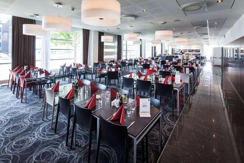 a dining room with tables and chairs with red napkins at Scandic Sluseholmen in Copenhagen