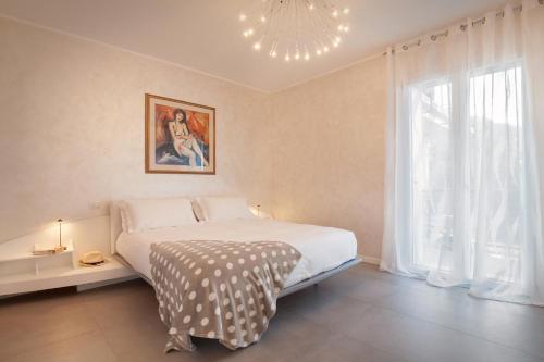 a bedroom with a large bed and a chandelier at Terrace of Wally - Apartment With Pool in Torri del Benaco
