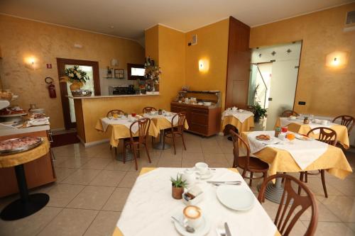 restauracja ze stołami i krzesłami oraz kuchnia w obiekcie Hotel Cris w Mestre