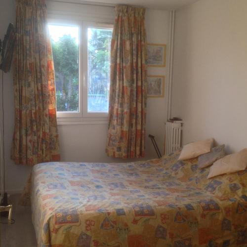 - une chambre avec un lit en face d'une fenêtre dans l'établissement Appartement lumineux à 20mn de Paris en RER A, à Maisons-Laffitte