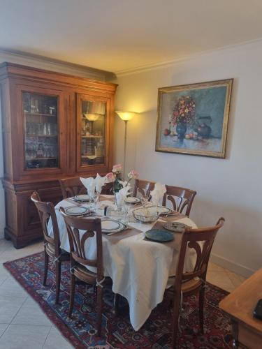 - une table à manger avec une nappe et des chaises blanches dans l'établissement Appartement lumineux à 20mn de Paris en RER A, à Maisons-Laffitte
