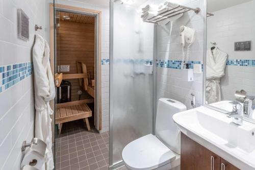a bathroom with a toilet and a sink and a shower at Scandic Tampere Koskipuisto in Tampere