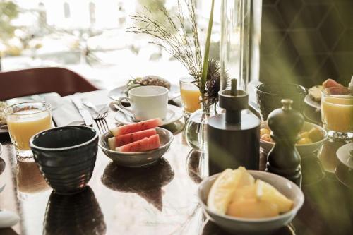 a table topped with bowls of fruit and drinks at Scandic Meilahti in Helsinki