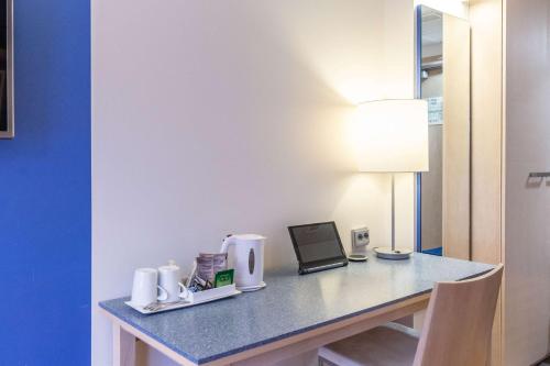 a desk with a laptop and a lamp on it at Scandic Hakaniemi in Helsinki