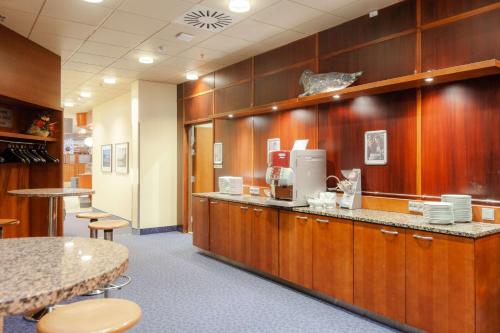 a restaurant with a counter and a table and chairs at Scandic Mikkeli in Mikkeli