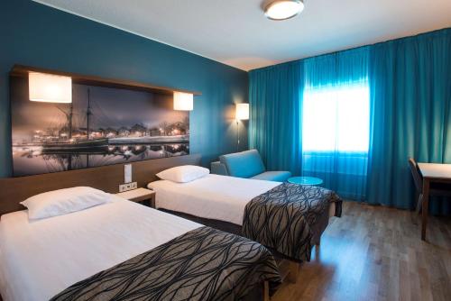 a hotel room with two beds and a window at Scandic Oulu Station in Oulu