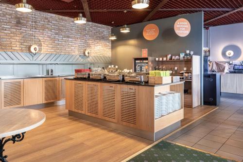 a restaurant with a counter with food on it at Scandic Oulu Station in Oulu
