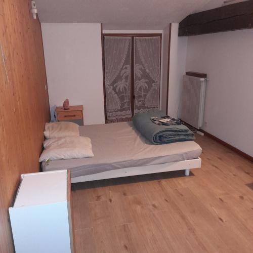 une petite chambre avec un lit et une fenêtre dans l'établissement maison JARRIE, à Jarrie