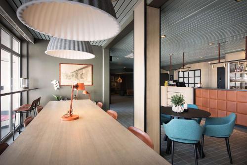 a dining room with a large wooden table and chairs at Scandic Vestfjord Lofoten in Svolvær