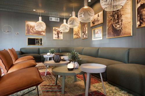 a waiting room with couches and tables and chandeliers at Scandic Vestfjord Lofoten in Svolvær