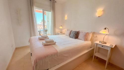 ネルハにあるUrb Chimenea Apartment Nerjaのタオルが敷かれた大きなベッドのある寝室