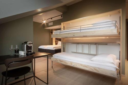 two bunk beds in a room with a desk at Scandic Voss in Vossevangen