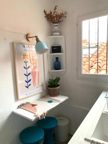 une chambre avec une table et deux tabourets bleus dans l'établissement Studio in historical monument in city center, à Montpellier