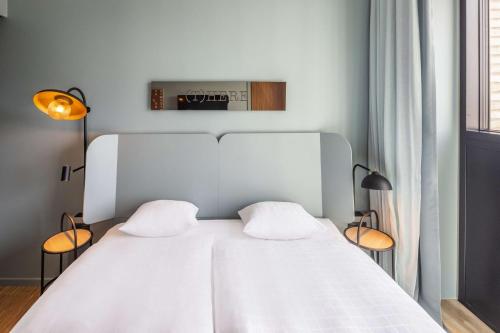 a bedroom with a white bed with two pillows at Scandic CPH Strandpark in Copenhagen