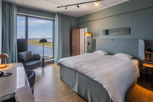 a hotel room with a large bed and a desk at Scandic CPH Strandpark in Copenhagen