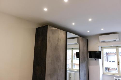 Habitación con un tabique y TV en la pared. en Domus Marconi Roma, en Roma