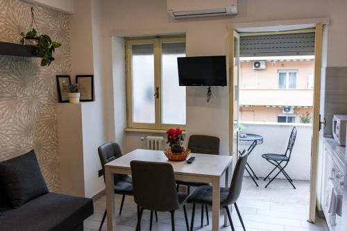 Una cocina y un comedor con mesa y sillas. en Domus Marconi Roma, en Roma