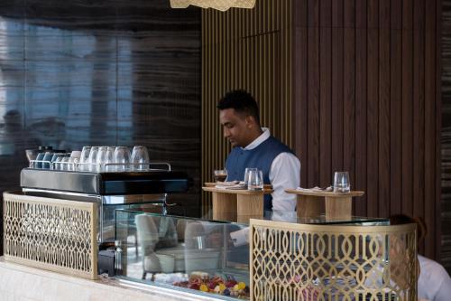 a man sitting at a table with a plate of food at Jumeirah Saadiyat Island Abu Dhabi in Abu Dhabi