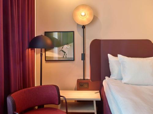 a hotel room with a bed and a desk and a lamp at Scandic Kiruna in Kiruna