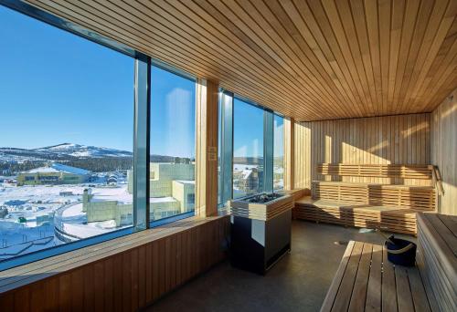 a room with large windows and a view of a snowy mountain at Scandic Kiruna in Kiruna