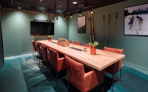 a conference room with a long wooden table and chairs at Scandic Kiruna in Kiruna