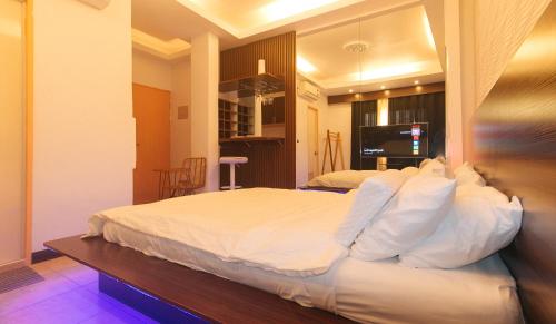 a bedroom with a large bed with white pillows at Movietelle by RedDoorz in Lapu Lapu City