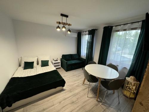 a bedroom with a bed and a table and a couch at Noclegi u Kostka Sarbinowo in Sarbinowo