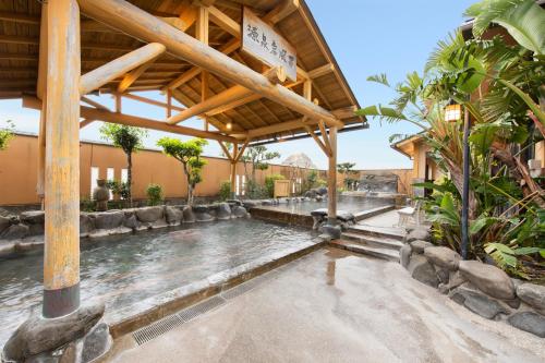 a swimming pool in a resort with a water feature at Ibusuki Kokoronoyado in Ibusuki
