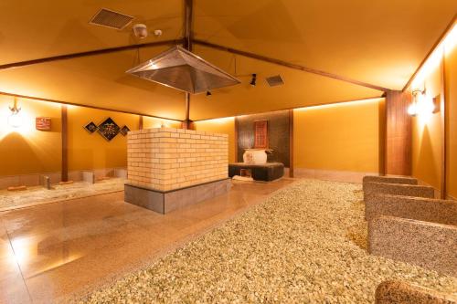 a large room with a brick fireplace in a room at Ibusuki Kokoronoyado in Ibusuki