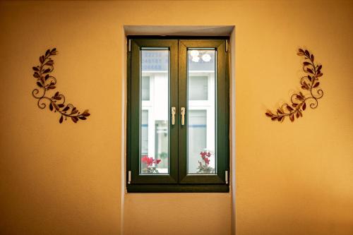 a door with a window on the side of a building at Σοχός Παραδοσιακές Οικίες- ΒΕΝΙΖΕΛΟΥ in Zokhós