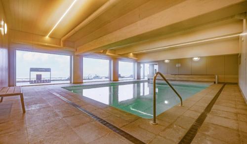 ein Schwimmbad in einem Gebäude mit einem großen Fenster in der Unterkunft Studio-M in Middelkerke