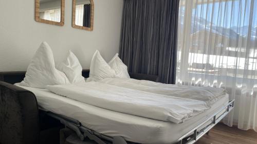 a bed with white sheets and pillows in a bedroom at Studio Haus Castello in Randa