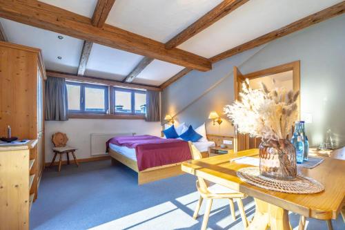 アウラッハ・バイ・キッツビュールにあるGasthof Auwirt in Aurachのベッドと花瓶が置かれたテーブルのある寝室