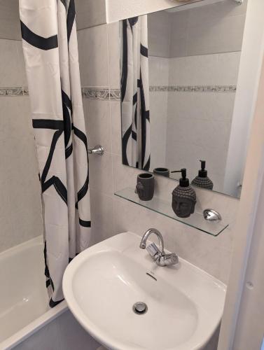 une salle de bain avec un lavabo et un rideau de douche dans l'établissement Nice center - 2 person apartment, à Nice