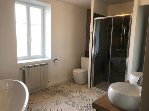 a bathroom with two sinks and a glass shower at Le domaine de la Belle Demeure Chambre et table d hôte in Saint-Genès-du-Retz