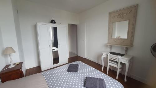 a bedroom with a bed and a table and a mirror at House with garden and view of Rouen in Rouen